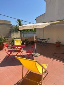 a patio with chairs and tables and an umbrella at Al Vecchio Convento in Orosei +12 photos