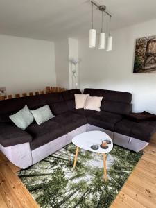 a living room with a black couch and a table at Ferienhaus Schülke in Buckow