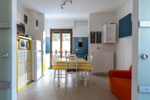 a kitchen with a table and a yellow and white kitchen at Relax nel verde in Gravere