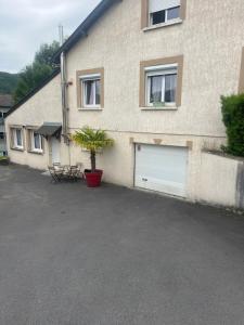 a building with two garage doors and a plant in a pot at Le feuillu Bogny-sur-Meuse in Braux +3 photos