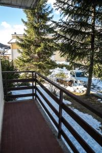 a balcony with a fence and a tree and snow at Relax nel verde in Gravere