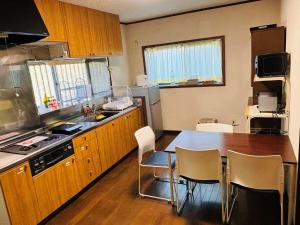 a kitchen with a table and a table and chairs at 伊勢ゲストハウスKitai in Ise