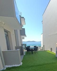 a balcony with a table and chairs and the ocean at ALTA MARE in Nea Peramos