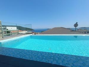 a large blue swimming pool with a view of the ocean at ALTA MARE in Nea Peramos