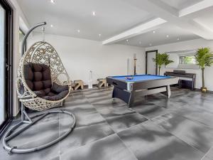 a room with a ping pong table and a swing at Villa avec jacuzzi, sauna&cinéma in Triel-sur-Seine