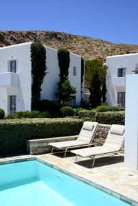 a villa with a swimming pool and two lounge chairs at ANEMI Folegandros in Karavostasi