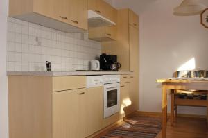 a kitchen with wooden cabinets and a stove top oven at Apart Gander in Kappl