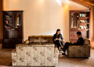 a man and woman sitting on a couch in a living room at Sinclairs Retreat Kalimpong in Kalimpong