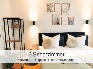 ein Schlafzimmer mit einem Bett mit zwei Kissen in der Unterkunft Newman Horizon Apartments Zirndorf - Playmobil Funpark, Nähe Messe Nürnberg und Fürth, 4 Pers, 24h Self Checkin, Waschmaschine, großer Parkplatz in Zirndorf