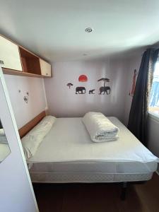 Una cama pequeña en una habitación pequeña con sombrillas en la pared. en Les Dunes, en Le Grau d'Agde