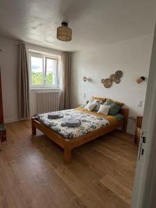 a bedroom with a bed and a window at La ferme de beau soleil Gîte et cabanes in Saint-Gilles-du-Mené