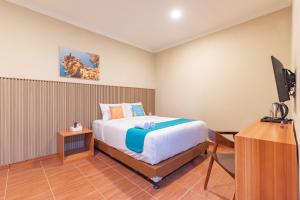 Ένα ή περισσότερα κρεβάτια σε δωμάτιο στο Sans Vibes Surapati Konforta Hotel