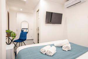 Un dormitorio con una cama, un televisor y una silla. en Pallaro 6 room, en Roma