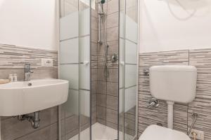 Un baño con inodoro, lavabo y ducha. en Pallaro 6 room, en Roma