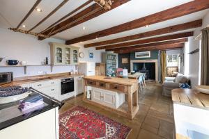 Una cocina con gabinetes blancos y una mesa. en Shellbraes Holiday Rental, en Matfen