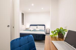 Un dormitorio con una cama y un escritorio con una computadora portátil. en Pallaro 6 room, en Roma