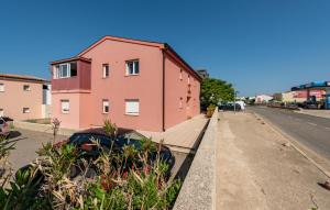 a pink building on the side of a street at 1 Bedroom Gorgeous Apartment In Pag in Pag