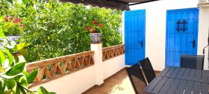a balcony with blue doors and a table and chairs at El Carmen de Sexi in Almuñécar
