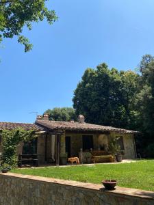 a stone house with a dog in front of it at Agriturismo Tenute di Hera - Via Francigena in Acquapendente