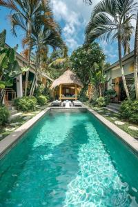 塞米亚克Villa Mint, 3Br Tropical Escape with Private pool and Lush Garden的棕榈树环绕的房子前的游泳池