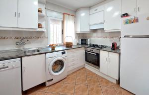 a kitchen with white cabinets and a washing machine at Awesome Home In Bétera in Bétera