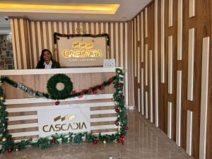 a woman standing behind a podium with christmas decorations at Cascadia Hotel Apartments by GF Greenland in Kigali +97 photos