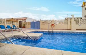 a swimming pool at a resort with blue chairs at Gorgeous Apartment In Fuengirola in Fuengirola