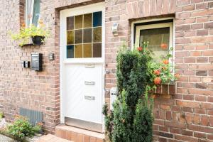 a white door on a brick house with flowers at Nice Apartment in Kleve in Kleve