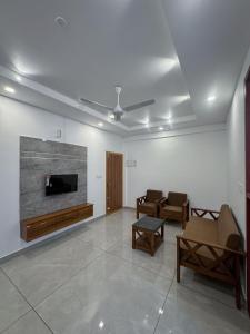 卡卡纳德The Nexus Hotel Kakkanad的配有平板电视和椅子的客厅