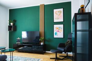 a living room with green walls and a flat screen tv at Nice Apartment in Kleve in Kleve