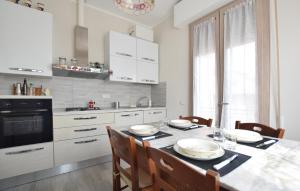 a kitchen with a table with chairs and a kitchen with white cabinets at Beautiful Apartment In Piano Di Mommio in Piano di Mommio