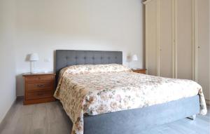 a bedroom with a bed with a floral bedspread and a nightstand at Beautiful Apartment In Piano Di Mommio in Piano di Mommio