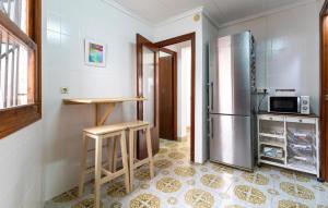 a kitchen with a refrigerator and a table and stool at Awesome Home In Torrevieja With Wifi in Torrevieja