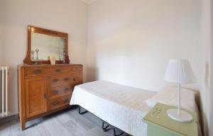 a bedroom with a bed and a dresser with a mirror at Beautiful Apartment In Piano Di Mommio in Piano di Mommio +11 photos