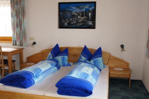 Una cama con almohadas azules y blancas. en Apart Gander, en Kappl