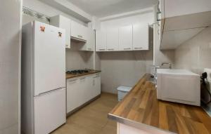 una cucina con mobili bianchi e un frigorifero bianco di Nice Home In Jerez De La Frontera a Jerez de la Frontera