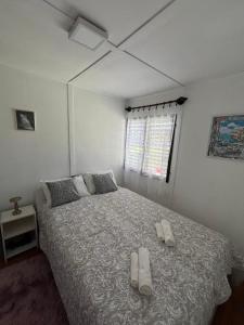 a bedroom with a bed with two slippers on it at Hibiscus Apartman in Balatonfenyves +6 photos