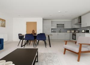 a kitchen and living room with a table and chairs at 1 Bed Flat near Syon Park in Isleworth