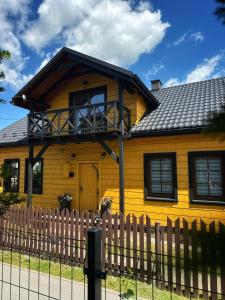 a yellow house with a fence in front of it at Dom Wypoczynkowy przy Szlaku OJCÓW in Ojców