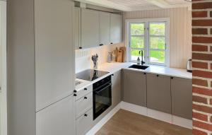 una cucina con mobili bianchi, un lavandino e una finestra di 3 Bedroom Cozy Home In Hejls a Hejls