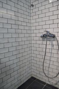 a white tiled shower with a hose in a bathroom at Sea front condo on the Gulf of Pagasitikos in Marathos