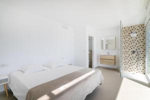 Un dormitorio blanco con una cama y un baño. en Villa Lizo, en El Campello 20 fotos más