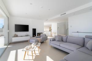 Una sala de estar con un sofá y un televisor. en Villa Lizo, en El Campello