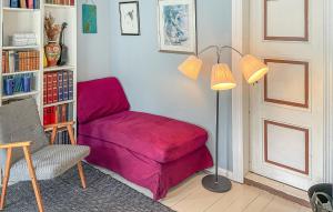 a living room with a red chair and a lamp at 4 Bedroom Pet Friendly Home In Farsund in Farsund