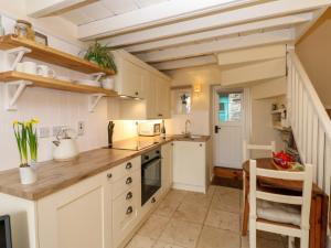 une cuisine avec des armoires blanches et un comptoir dans l'établissement Lavender Cottage, à Askrigg 25 autres photos