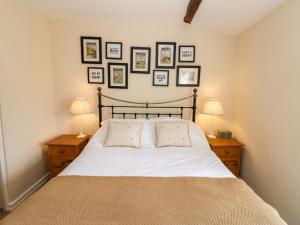 une chambre avec un lit avec trois tableaux au mur dans l'établissement Lavender Cottage, à Askrigg