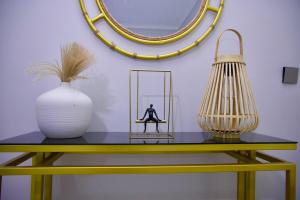 a yellow table with a vase and a mirror at Luxury Comfort in Kampala