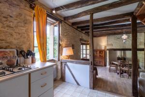 a kitchen with a stove top oven in a room at Moulin de la Grenaderie in Sergeac