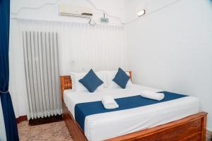 a bedroom with a large bed with blue and white pillows at Coastal Heaven Villa in Trincomalee +84 photos