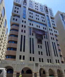 a tall building with a sign on the side of it at Artal Al Alami Hotel in Al Madinah
